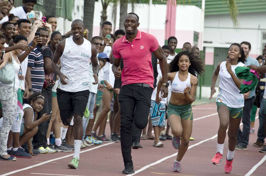 Non tradisce mai, Bolt: eccolo mentre corre con un gruppo di teenager a Rio de Janeiro. Afp